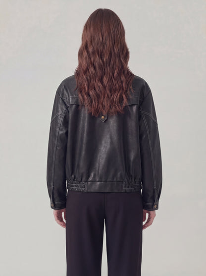 Person wearing a black leather jacket from behind on a plain background