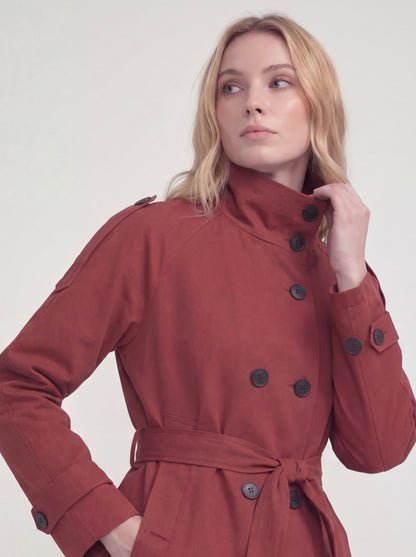 Woman wearing a red coat with black buttons on a white background
