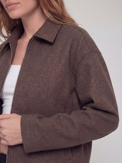 Brown jacket worn by a person on a white background